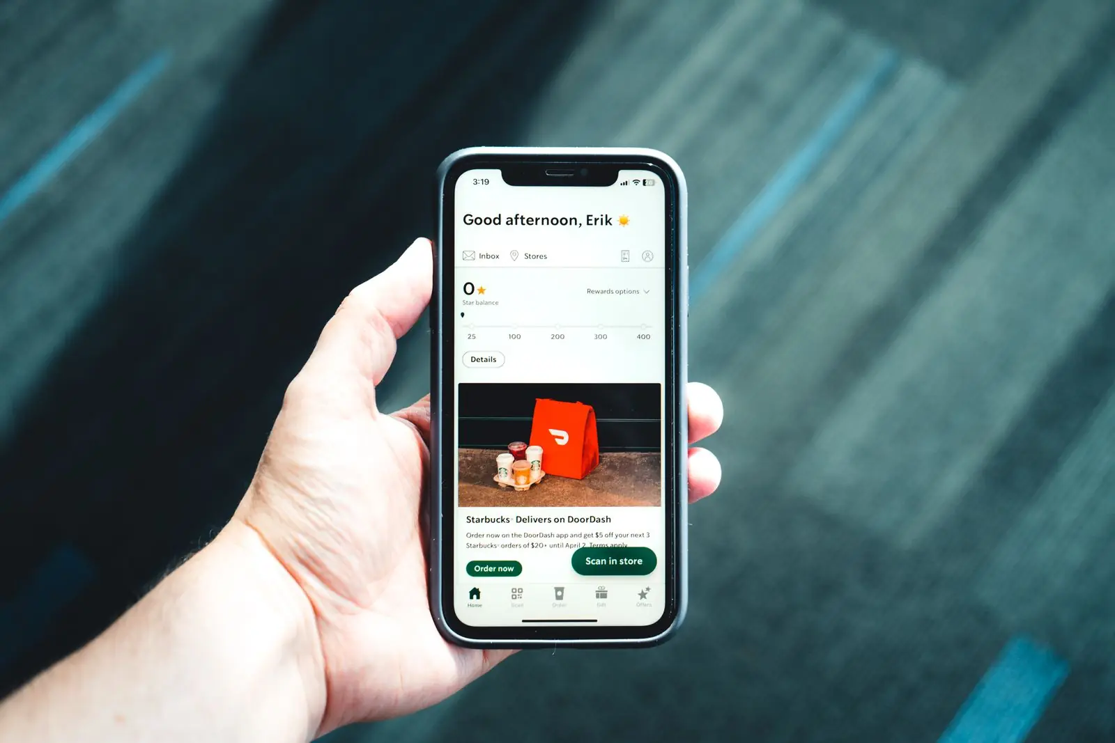 Ekranında bir mobil uygulama açık olan telefonu tutan el